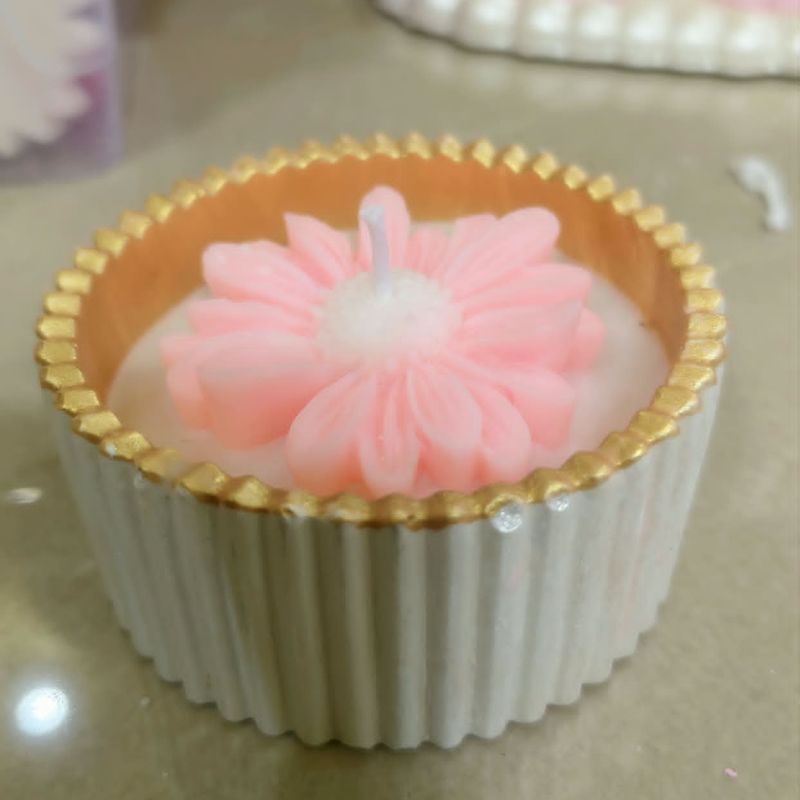 Pink daisy candle in a white ribbed cup with a beaded gold rim